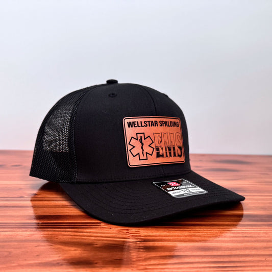 Black cap with leather patch on a wooden surface